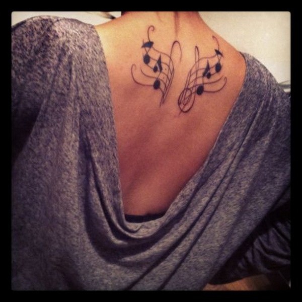 Music Wing Tattoo en la parte superior de la espalda. 
