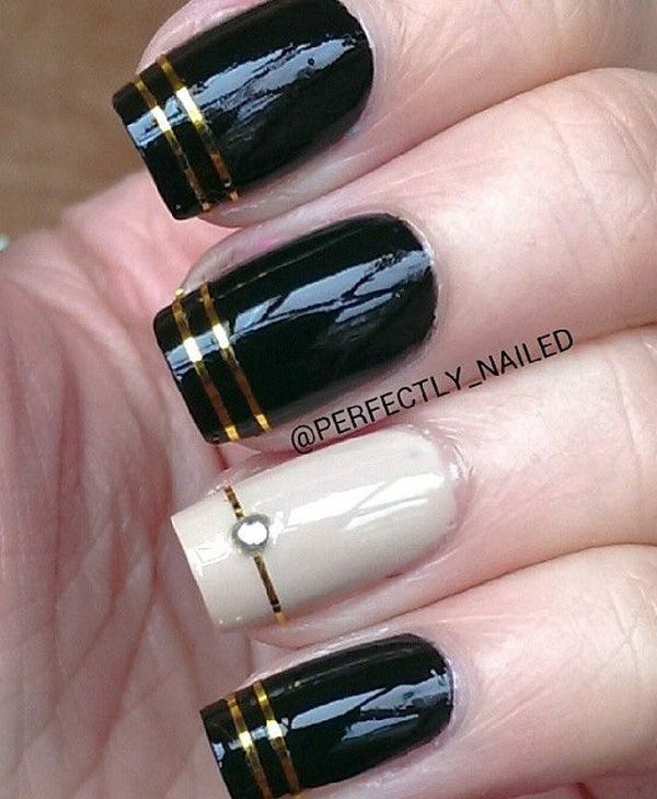 Black Nail Art Design con Gold Stripes para detalles. 