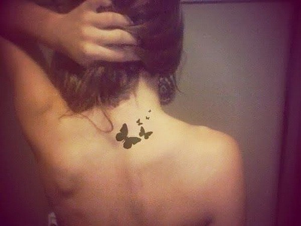 Mariposa negra en la parte posterior del cuello del tatuaje. 