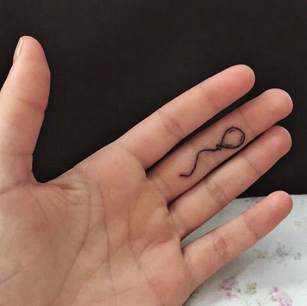 Tatuaje de globo de línea mínima en el dedo. 
