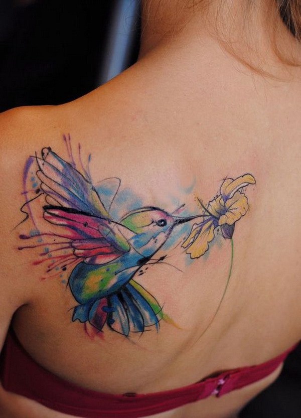 Tatuaje colorido del pájaro y de la flor en la parte posterior. 