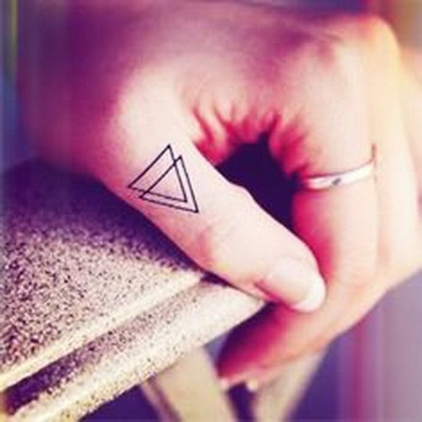 Doble triángulo tatuaje en el dedo. 