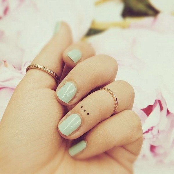 Tatuajes de puntos simples en el dedo. 