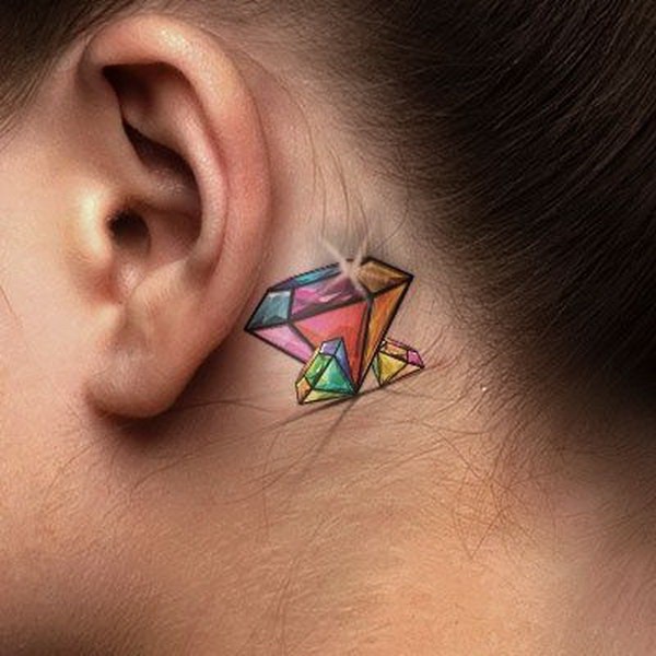 Mujer con el tatuaje de diamantes de colores detrás de la oreja. 