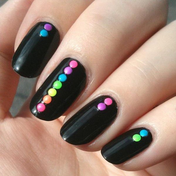 Uñas negras con puntos de colores en la parte superior. 