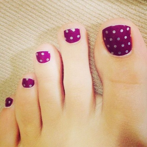 Lunares en las uñas del dedo del pie púrpura. 