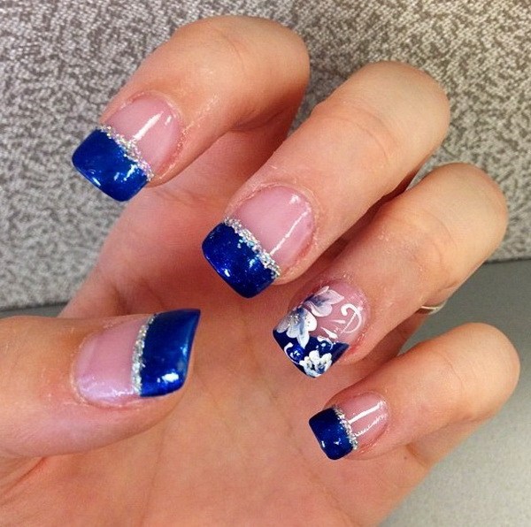 Azul con punta francesa diseño de uñas acentuado con un poco de flores. 