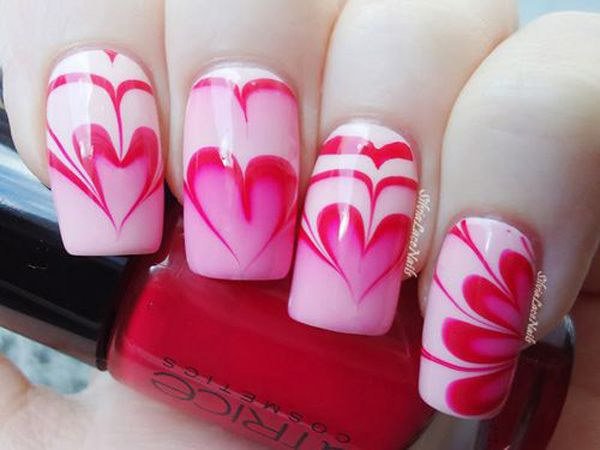Un corazón y una flor en forma de diseño de arte de uñas de mármol. 