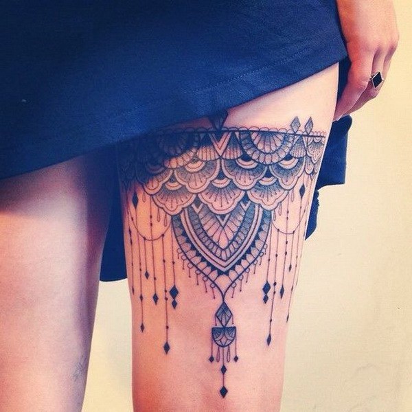Impresionante tatuaje de muslo con diseño de encaje. 