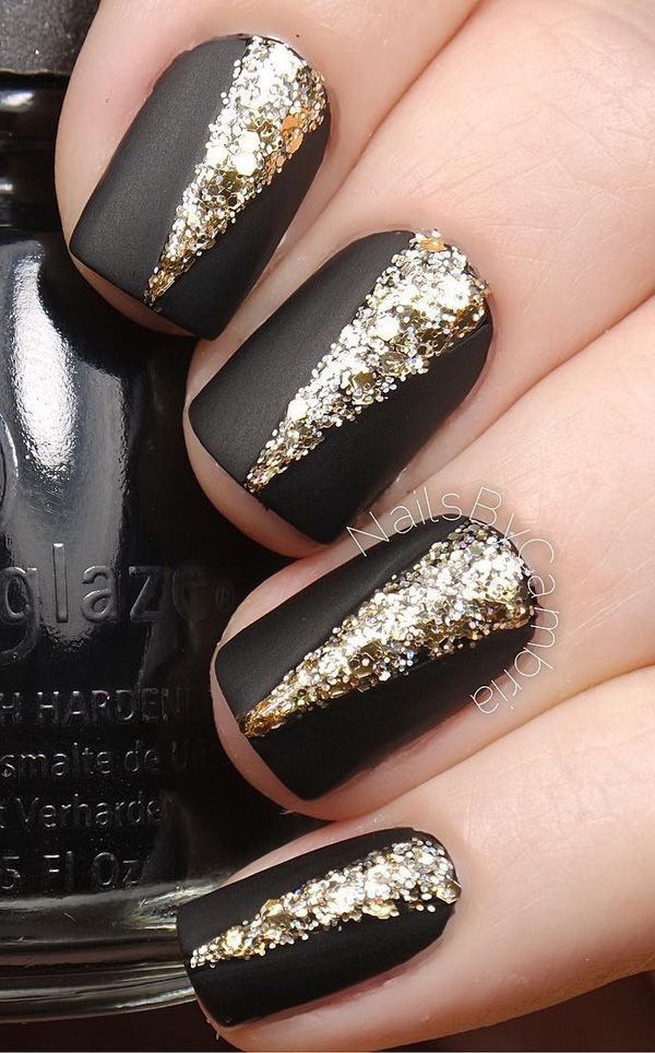 Elegantes uñas negras mate con adornos de oro en la parte superior. 